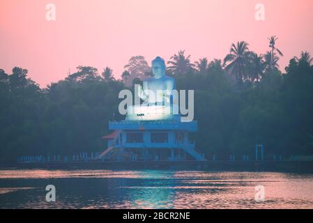 BENTOTA, SRI LANKA - 16. FEBRUAR 2020: Skulptur eines sitzenden Buddha vor dem Hintergrund der Morgendämmerung. Buddhistischer Tempel Udakotuwa-Tempel Stockfoto