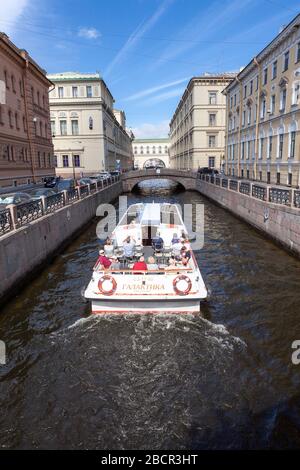 ST. PETERSBURG, RUSSIA-CIRCA Aug, 2018: Flaches offenes Schiff kommt auf dem Winterkanal zur Brücke, um in den Newa-Fluss zu gelangen. Transport und Bootstour für Stockfoto