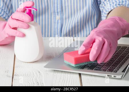 Coronavirus Desinfektion des Arbeitsbereichs Reinigung Desinfektionstücher, um die Oberfläche der Tastatur zu reinigen. Stoppen Sie die Ausbreitung des Corona-Virus. Frau mit Schutzkleidung Stockfoto