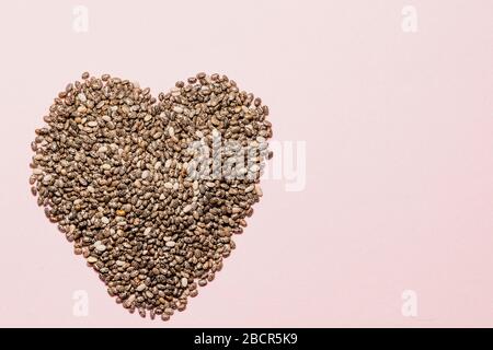 Herz aus chia Samen auf pinkfarbenem, gesundem Leben und Ernährungskonzept Stockfoto