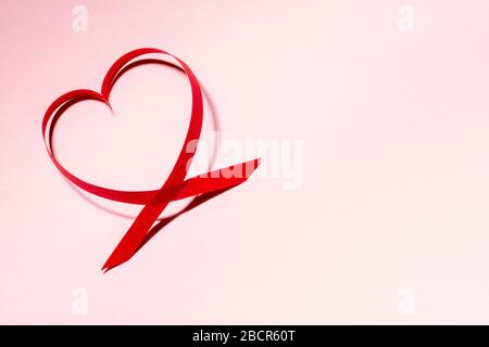 Rote Papier-Herzform auf pinkfarbenem Hintergrund mit Kopierraum, Valentinstag- und Muttertagskarte, Liebeskonzept Stockfoto