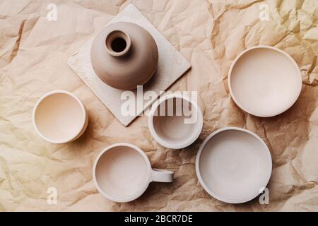 Braune, nicht bemalte Töpfe und Schüsseln auf Handwerkspapier Stockfoto