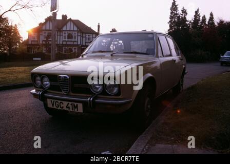 Ein cremefarbenes Alfa Romeo Alfetta Auto parkte vor einem Haus der Tudor-Familie in den Vororten von London, Hatch End, Middlesex, Großbritannien 1973 Stockfoto