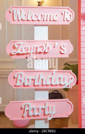 Nummer eins auf violettem Hintergrund . Das Kind ist pink gekleidet. Geburtstag eines alten Kindes . Welkome zu Zeynebs Birthdays Party. Baku, Aserbaidschan. 16 Stockfoto