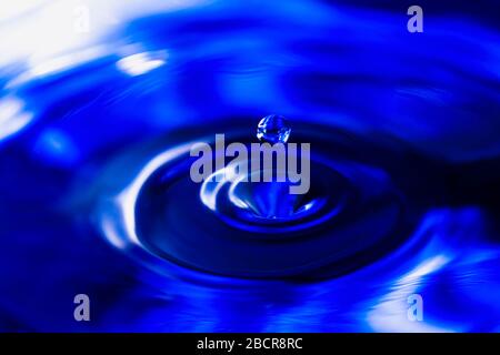 Blauer Wassertropfen fällt, Wasserspritzwasserhintergrund Stockfoto
