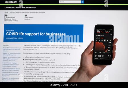 Covid 19 UK Government Business Information & Smartphone FTSE Marktrückgang Stockfoto