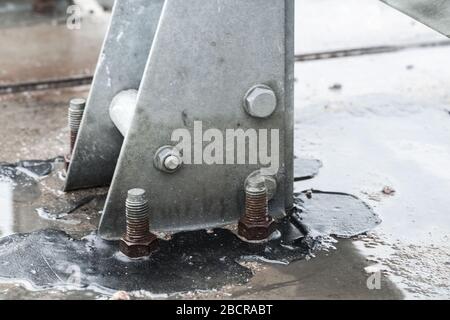 Abstrakte nasse graue Metallstrukturen in der Industrie, die mit Schrauben verbunden sind, Nahaufnahme mit selektivem Weichfokus Stockfoto