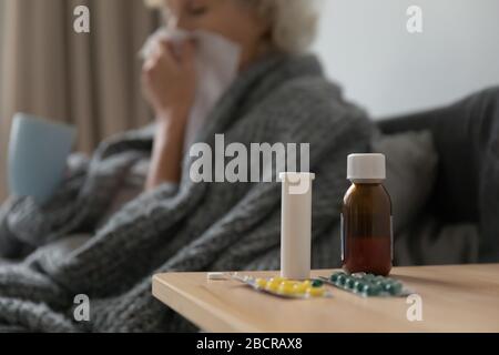 Schließen Sie Glas- und Plastikflaschen mit Pillen auf dem Tisch. Stockfoto