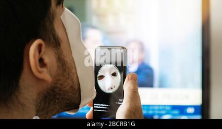 Paris, Frankreich - 10. November. 2017: Nahaufnahme der Meldung "Face behind" auf dem neuen Apple iPhone XS Pro mit der Funktion "Face ID Virtual Facial Recognition" mit einem anonymen Hacker, der eine Maske trägt Stockfoto