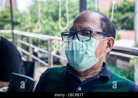 Makassar, Süd-Sulawesi, Indonesien. April 2020. Ein Mann, der eine Maske im Mund trägt, sitzt auf der Veranda seines Hauses in der Stadt Makassar, Provinz Süd-Sulawesi, Indonesien. Dieser Mann bleibt im Haus, um die Verbreitung von Coronavirus Credit zu vermeiden: Herwin Bahar/ZUMA Wire/Alamy Live News Stockfoto