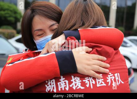 Hengyang, chinesische Provinz Hunan. April 2020. Ein Arzt begrüßt und umarmt ihren Kollegen, der die von Viren heimgeplagene Provinz Hubei unterstützt hat und nach der Quarantäne in einem ausgewiesenen Hotel in Hengyang, der zentralchinesischen Provinz Hunan, am 5. April 2020, wieder im zweiten angeschlossenen Krankenhaus der Universität Südchina arbeitet. Diese Sanitäter kehrten am Sonntag nach Quarantäne und Erholung in ihre Positionen zurück. Kredit: Cao Zhengping/Xinhua/Alamy Live News Stockfoto