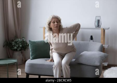 Ungesunde ältere Frau, die an einer Radikulitis-Arthritis leidet. Stockfoto