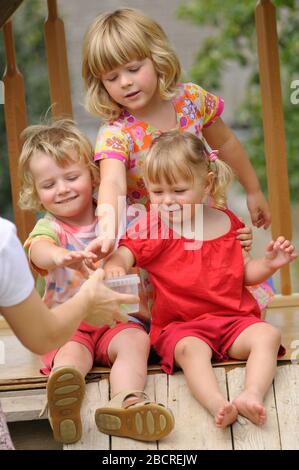 Die drei kleinen lächelnden Mädchen im Park Stockfoto