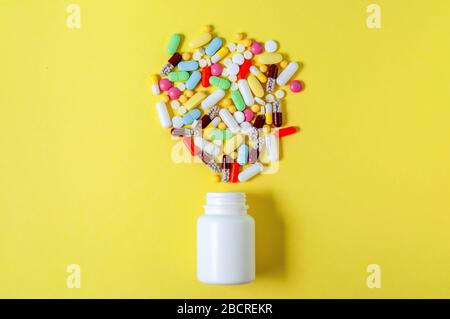 Bunte verschiedene pharmazeutische Pillen, Tabletten, Kapseln und Flasche auf gelbem Hintergrund. Stockfoto