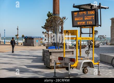 Bournemouth, Dorset, Großbritannien. April 2020. Ein LED-Schild warnt Menschen vor sozialer Distanzierung am Strand in Bournemouth, Großbritannien während der Coronavirus Pandemie. Kredit: Thomas Faull/Alamy Live News Stockfoto