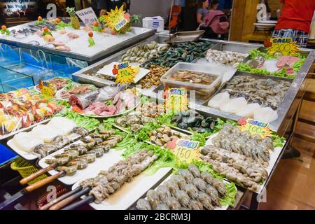 Schalentiere, einschließlich Garnelen, Muscheln, Krebse und Tintenfisch, zusammen mit Fisch, der in einem Fischhändler auf dem nassen Markt verkauft wird, Kata Beach, Phuket, Thailand Stockfoto