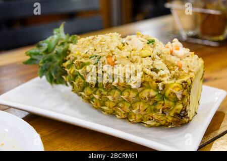 Gebratener Reis wird in einer ausgehöhlten Ananas in einem Restaurant in Thailand serviert. Stockfoto