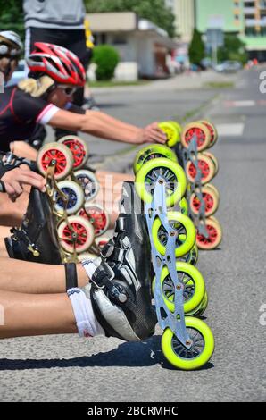 Roller rutzt die Räder vor dem Beginn des städtischen Rennens, um ein gesundes und aktives Leben zu erhalten Stockfoto