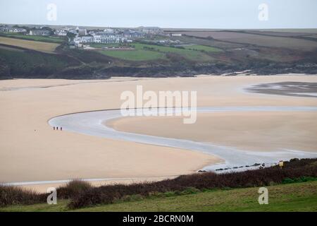 Eine Familie mit ihrem Hund gesellige Distanzierung wher, der Fluss Gannel fließt ins Meer am Strand von Crantock, in der Nähe von Newquay, Cornwall Stockfoto