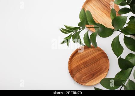 Holzplatten und grüne Blätter auf weißem Grund Stockfoto