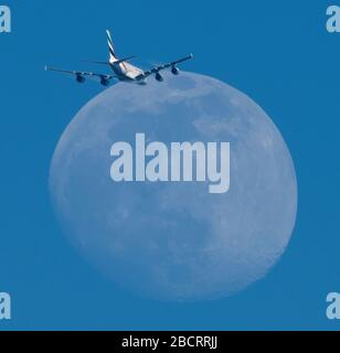 Wimbledon, London, Großbritannien. April 2020. 90 % der beleuchteten, schwungvollen Monde werden von einem Emirates-Flug durchzogen, der London-Heathrow nach Dubai in klarem blauem Himmel am frühen Abend startet. Kredit: Malcolm Park/Alamy Live News. Stockfoto