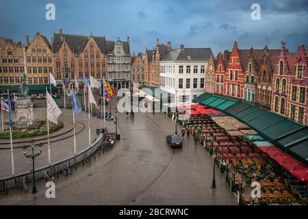 Schöne Luftaufnahme auf dem Grote Markt in Brügge an einem bewölkten Tag. Bunte traditionelle Häuser, Bars und Restaurants, Menschen, Pferde gezogen Stockfoto