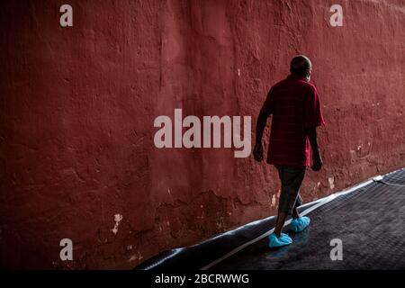 02. April 2020, Peru, Lima: Ein obdachloser Mann mit geschützten Füßen läuft durch eine Stierkampfarena, die im Kampf gegen das Coronavirus in Notunterkünfte für ärmere Menschen umgewandelt wurde. Menschen ohne Wohnung können während der Regierungskurie in der Arena bleiben. Peruaner dürfen das Haus nur verlassen, um Lebensmittel oder Medikamente zu kaufen. Bis zum 03.04.2020 waren 1414 Menschen im südamerikanischen Land nachweislich mit dem neuen Coronavirus infiziert, 55 Patienten starben. Foto: Cesar Campos / dpa Stockfoto