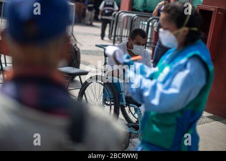 02. April 2020, Peru, Lima: Menschen arbeiten mit Schutzanzügen in einer Notunterkunft, die gebaut wurde, um die Ausbreitung von Coronavirus für Obdachlose in einer Stierkampfarena zu verhindern. Menschen ohne Wohnung können während der Regierungskurie in der Arena bleiben. Peruaner dürfen das Haus nur verlassen, um Lebensmittel oder Medikamente zu kaufen. Bis zum 03.04.2020 waren 1414 Menschen im südamerikanischen Land nachweislich mit dem neuen Coronavirus infiziert, 55 Patienten starben. Foto: Cesar Campos / dpa Stockfoto