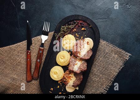 Gegrillte Schweinekoteletts mit Kartoffelpüree. Auf einem dunklen Holzhintergrund, rustikaler Stil. Food-Foto. Stockfoto