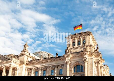 Berlin, Deutschland - 9. Dezember 2019: Blick auf einen oberen Teil des Reichstags-Gebäudes mit deutscher Flagge am Wind Stockfoto