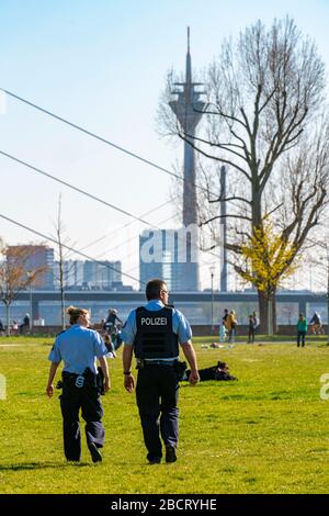 Polizeipatrouille überwacht das Kontaktverbot, Rheinpark, DŸsseldorf am Rhein während der Coronakrise werden die Kontaktverbote, die Distanz wird meist eingehalten Stockfoto