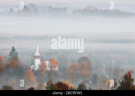 Blick auf das siebenbürgische Dorf im Nebel, Morgenbild in Rumänien Stockfoto