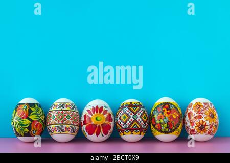 Ostergeschenkkarte mit bunten Ostereiern auf blauem Hintergrund. Leerplatz, Platz. Konzept christlicher Traditionen Stockfoto