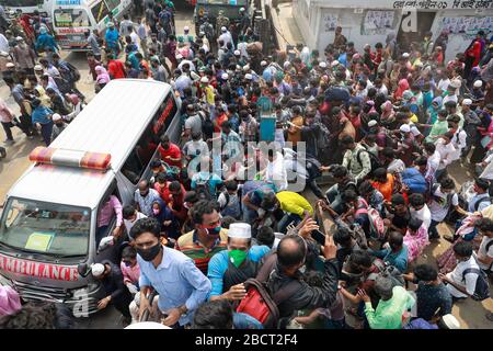 Mawa, Dhaka, Bangladesch. April 2020. Tausende von wiederverarbeiteten Kleidungsarbeitern aus dem ganzen Land waren in den letzten Tagen entweder gegangen oder nutzten alternative Transpirationsmethoden, um die Hauptstadt Dhaka zu erreichen, da die Eigentümer beschlossen hatten, die Fabriken inmitten einer staatlich erzwungenen weichen Abschaltung zu eröffnen, um zu verhindern, dass sich das neue Coronavirus weiter ausbreitet. Aber nach harschen Kritikpunkten war die BGMEA gezwungen, die Fabriken bis zum 11. April geschlossen zu halten. Den Arbeitern wurde gesagt, sie sollten nach Hause gehen, als sie am Sonntagmorgen in die Fabriken gingen, um sich der Arbeit anzuschließen. Diese photoss von Menschen, die in ihr Dorf hom zurückkehren Stockfoto