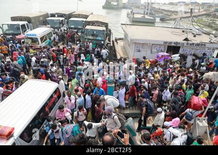 Mawa, Dhaka, Bangladesch. April 2020. Tausende von wiederverarbeiteten Kleidungsarbeitern aus dem ganzen Land waren in den letzten Tagen entweder gegangen oder nutzten alternative Transpirationsmethoden, um die Hauptstadt Dhaka zu erreichen, da die Eigentümer beschlossen hatten, die Fabriken inmitten einer staatlich erzwungenen weichen Abschaltung zu eröffnen, um zu verhindern, dass sich das neue Coronavirus weiter ausbreitet. Aber nach harschen Kritikpunkten war die BGMEA gezwungen, die Fabriken bis zum 11. April geschlossen zu halten. Den Arbeitern wurde gesagt, sie sollten nach Hause gehen, als sie am Sonntagmorgen in die Fabriken gingen, um sich der Arbeit anzuschließen. Diese photoss von Menschen, die in ihr Dorf hom zurückkehren Stockfoto