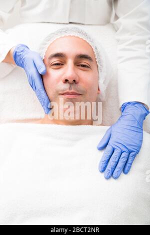 Porträt eines lächelnden Mannes, der im Schönheitssalon liegt Stockfoto