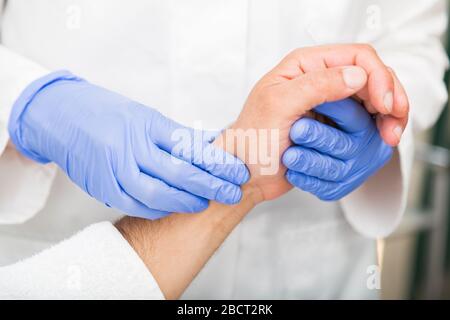 Geschlossen von der Hand des Arztes misst den Puls des Patienten Stockfoto
