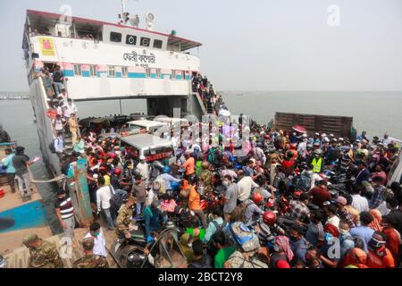 Mawa, Dhaka, Bangladesch. April 2020. Tausende von wiederverarbeiteten Kleidungsarbeitern aus dem ganzen Land waren in den letzten Tagen entweder gegangen oder nutzten alternative Transpirationsmethoden, um die Hauptstadt Dhaka zu erreichen, da die Eigentümer beschlossen hatten, die Fabriken inmitten einer staatlich erzwungenen weichen Abschaltung zu eröffnen, um zu verhindern, dass sich das neue Coronavirus weiter ausbreitet. Aber nach harschen Kritikpunkten war die BGMEA gezwungen, die Fabriken bis zum 11. April geschlossen zu halten. Den Arbeitern wurde gesagt, sie sollten nach Hause gehen, als sie am Sonntagmorgen in die Fabriken gingen, um sich der Arbeit anzuschließen. Diese photoss von Menschen, die in ihr Dorf hom zurückkehren Stockfoto