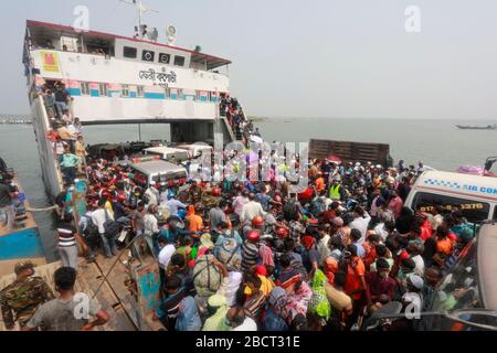 Mawa, Dhaka, Bangladesch. April 2020. Tausende von wiederverarbeiteten Kleidungsarbeitern aus dem ganzen Land waren in den letzten Tagen entweder gegangen oder nutzten alternative Transpirationsmethoden, um die Hauptstadt Dhaka zu erreichen, da die Eigentümer beschlossen hatten, die Fabriken inmitten einer staatlich erzwungenen weichen Abschaltung zu eröffnen, um zu verhindern, dass sich das neue Coronavirus weiter ausbreitet. Aber nach harschen Kritikpunkten war die BGMEA gezwungen, die Fabriken bis zum 11. April geschlossen zu halten. Den Arbeitern wurde gesagt, sie sollten nach Hause gehen, als sie am Sonntagmorgen in die Fabriken gingen, um sich der Arbeit anzuschließen. Diese photoss von Menschen, die in ihr Dorf hom zurückkehren Stockfoto