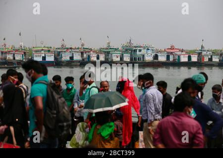 Mawa, Dhaka, Bangladesch. April 2020. Tausende von wiederverarbeiteten Kleidungsarbeitern aus dem ganzen Land waren in den letzten Tagen entweder gegangen oder nutzten alternative Transpirationsmethoden, um die Hauptstadt Dhaka zu erreichen, da die Eigentümer beschlossen hatten, die Fabriken inmitten einer staatlich erzwungenen weichen Abschaltung zu eröffnen, um zu verhindern, dass sich das neue Coronavirus weiter ausbreitet. Aber nach harschen Kritikpunkten war die BGMEA gezwungen, die Fabriken bis zum 11. April geschlossen zu halten. Den Arbeitern wurde gesagt, sie sollten nach Hause gehen, als sie am Sonntagmorgen in die Fabriken gingen, um sich der Arbeit anzuschließen. Diese photoss von Menschen, die in ihr Dorf hom zurückkehren Stockfoto