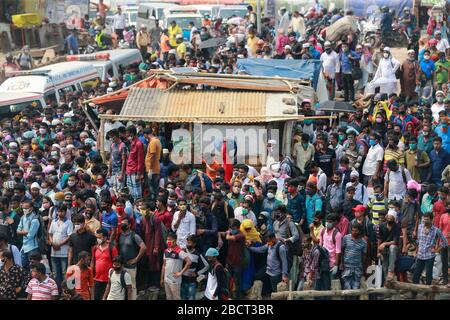 Mawa, Dhaka, Bangladesch. April 2020. Tausende von wiederverarbeiteten Kleidungsarbeitern aus dem ganzen Land waren in den letzten Tagen entweder gegangen oder nutzten alternative Transpirationsmethoden, um die Hauptstadt Dhaka zu erreichen, da die Eigentümer beschlossen hatten, die Fabriken inmitten einer staatlich erzwungenen weichen Abschaltung zu eröffnen, um zu verhindern, dass sich das neue Coronavirus weiter ausbreitet. Aber nach harschen Kritikpunkten war die BGMEA gezwungen, die Fabriken bis zum 11. April geschlossen zu halten. Den Arbeitern wurde gesagt, sie sollten nach Hause gehen, als sie am Sonntagmorgen in die Fabriken gingen, um sich der Arbeit anzuschließen. Diese photoss von Menschen, die in ihr Dorf hom zurückkehren Stockfoto