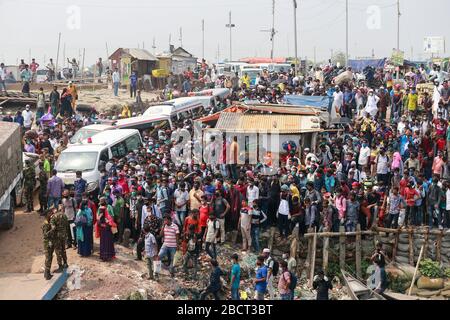 Mawa, Dhaka, Bangladesch. April 2020. Tausende von wiederverarbeiteten Kleidungsarbeitern aus dem ganzen Land waren in den letzten Tagen entweder gegangen oder nutzten alternative Transpirationsmethoden, um die Hauptstadt Dhaka zu erreichen, da die Eigentümer beschlossen hatten, die Fabriken inmitten einer staatlich erzwungenen weichen Abschaltung zu eröffnen, um zu verhindern, dass sich das neue Coronavirus weiter ausbreitet. Aber nach harschen Kritikpunkten war die BGMEA gezwungen, die Fabriken bis zum 11. April geschlossen zu halten. Den Arbeitern wurde gesagt, sie sollten nach Hause gehen, als sie am Sonntagmorgen in die Fabriken gingen, um sich der Arbeit anzuschließen. Diese photoss von Menschen, die in ihr Dorf hom zurückkehren Stockfoto