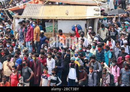 Mawa, Dhaka, Bangladesch. April 2020. Tausende von wiederverarbeiteten Kleidungsarbeitern aus dem ganzen Land waren in den letzten Tagen entweder gegangen oder nutzten alternative Transpirationsmethoden, um die Hauptstadt Dhaka zu erreichen, da die Eigentümer beschlossen hatten, die Fabriken inmitten einer staatlich erzwungenen weichen Abschaltung zu eröffnen, um zu verhindern, dass sich das neue Coronavirus weiter ausbreitet. Aber nach harschen Kritikpunkten war die BGMEA gezwungen, die Fabriken bis zum 11. April geschlossen zu halten. Den Arbeitern wurde gesagt, sie sollten nach Hause gehen, als sie am Sonntagmorgen in die Fabriken gingen, um sich der Arbeit anzuschließen. Diese photoss von Menschen, die in ihr Dorf hom zurückkehren Stockfoto