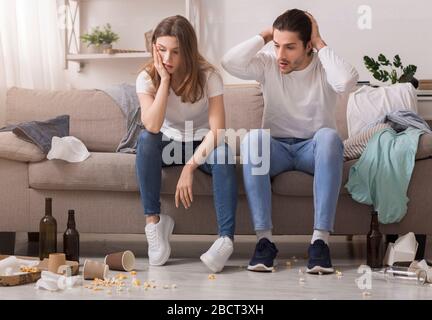 Ein tausendjähriges Paar wacht in EINEM unordentlichen Zimmer nach der Party auf Stockfoto