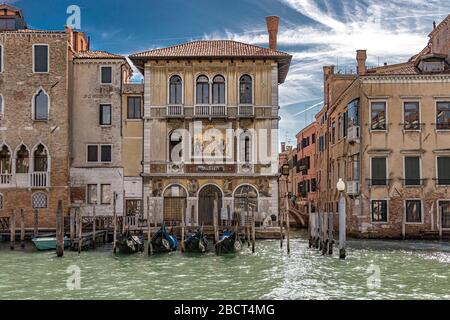 Gondeln vor dem Palazzo Salviati ein Palast, der 1924 am Canale Grande im Stadtteil Dorsoduro von Venedig, Italien, erbaut wurde Stockfoto