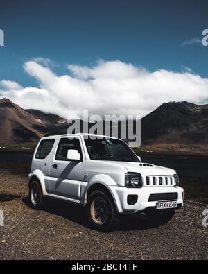 4x4 fahren Jeep Suzuki Jimny Parkplatz vor dem schönen Berg.Island Stockfoto