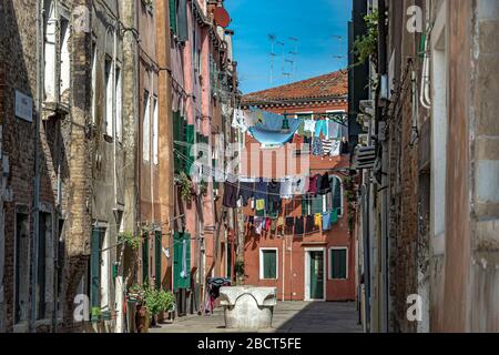 Waschen hängen an der Wäscheleine zwischen den Häusern in Corte Calle Colonne, einem kleinen engen Innenhof in Venedig, Italien Stockfoto