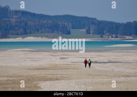 Forggensee mit zwei menschlichen Formen in der Ferne Stockfoto