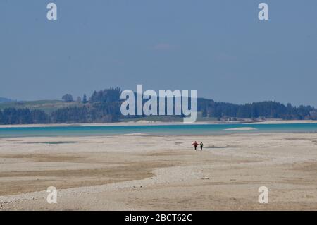 Forggensee mit zwei menschlichen Formen in der Ferne Stockfoto