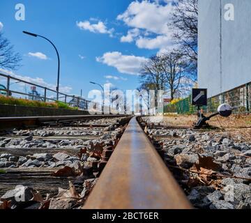 Tiefwinkel geschossen auf einer Bahngleise einer Eisenbahnlinie für Güterzüge in einem Gewerbegebiet in Berlin mit dem Schwerpunkt im Vordergrund. Stockfoto